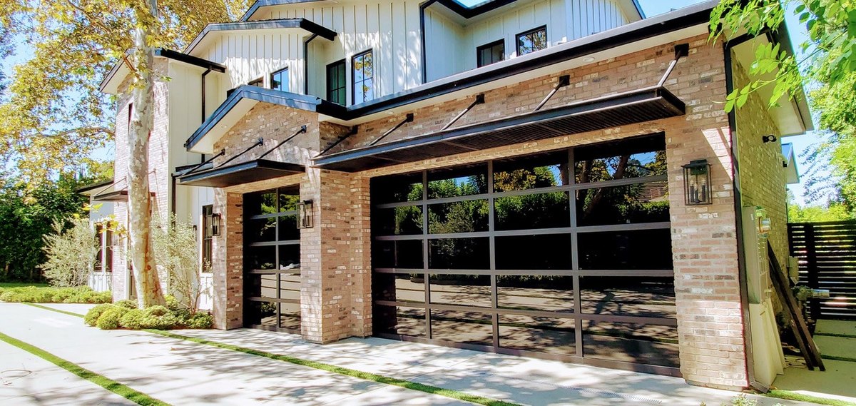 Black-framed glass garage doors set into a pale masonry facade.